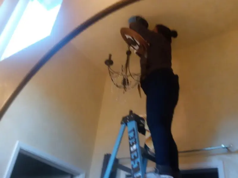 Electrician installing a chandelier in a Turlock residence
